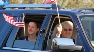 Student and Veteran in Car waiving flags